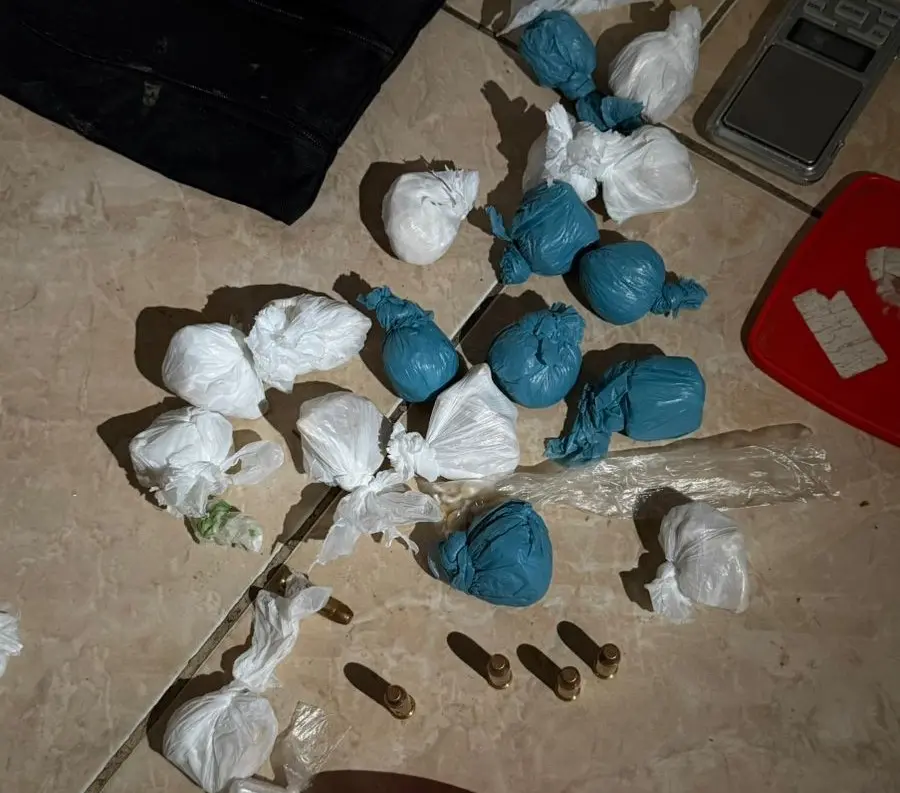 Foto de substância ilegal envolvida com drogas, incluindo múltiplas embalagens pequenas, papéis, e balas, indicativa de uso ou tráfico de entorpecentes.