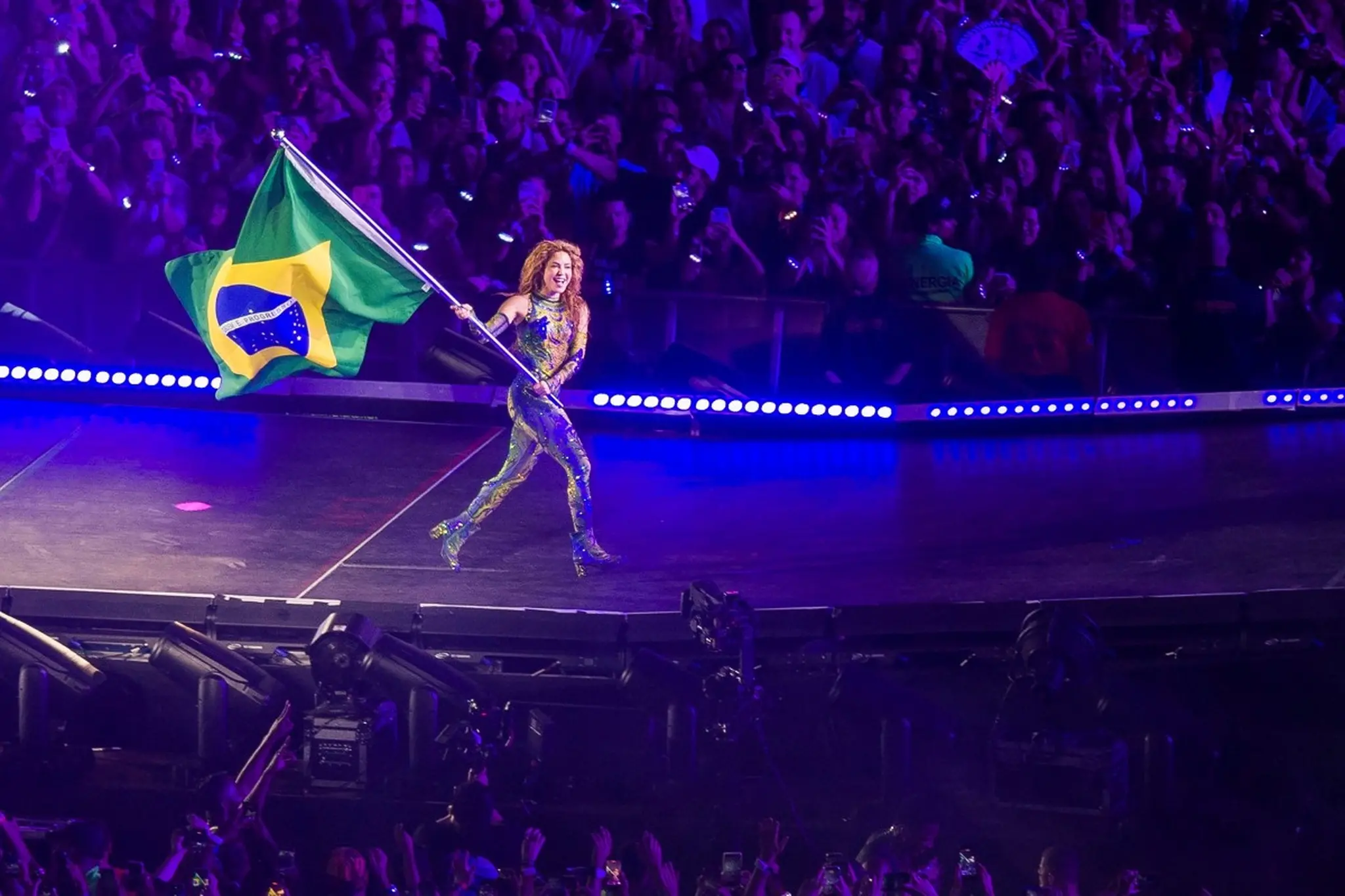 Shakira carrega bandeira do Brasil.