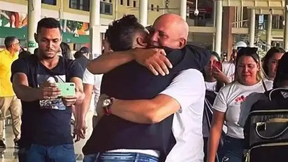Mulher abraça pai biológico.