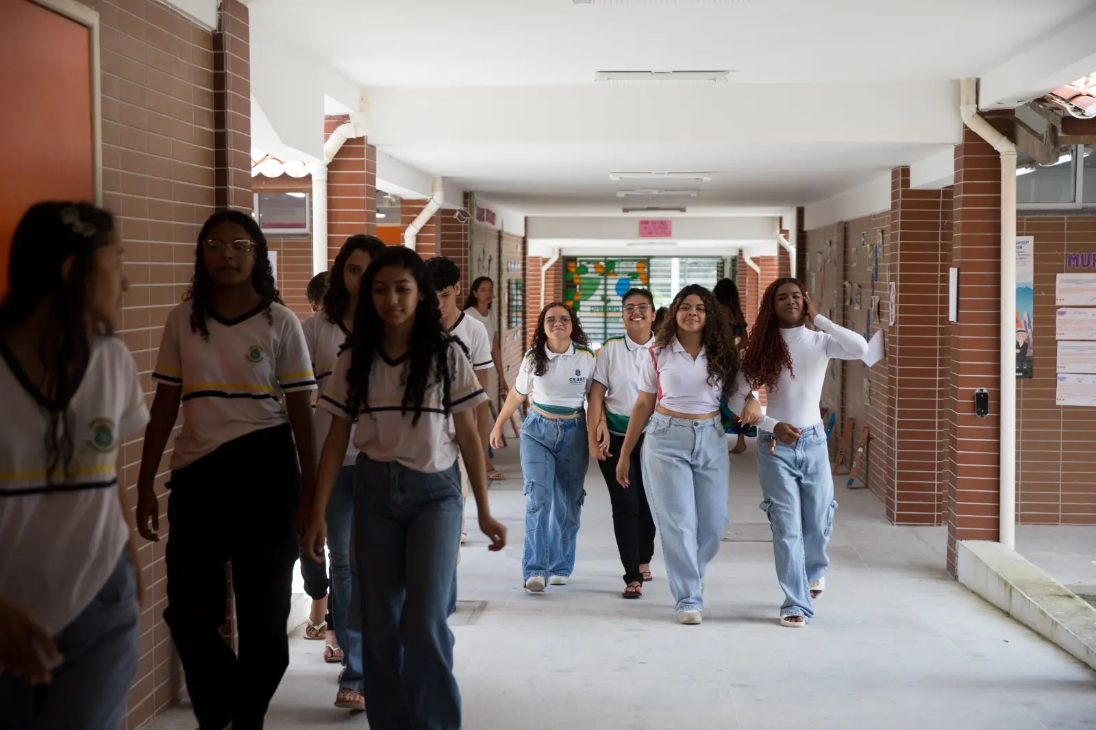 alunos andando em grupo no corredor de uma escola