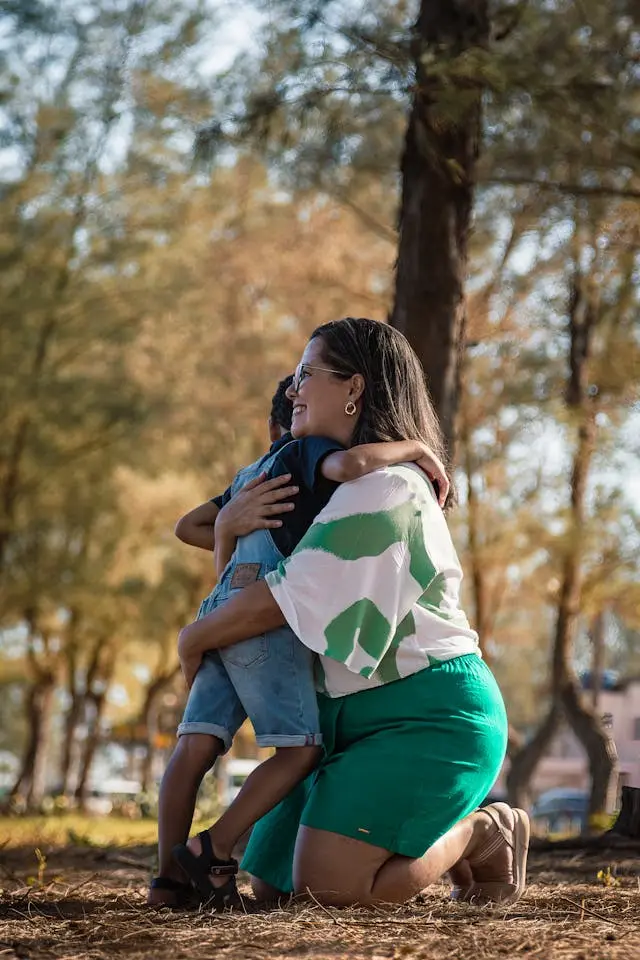 Mãe abraçando filho em uma floresta