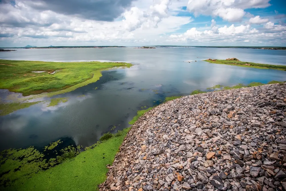imagem das águas do açude castanhão e um acumulado de pedras.