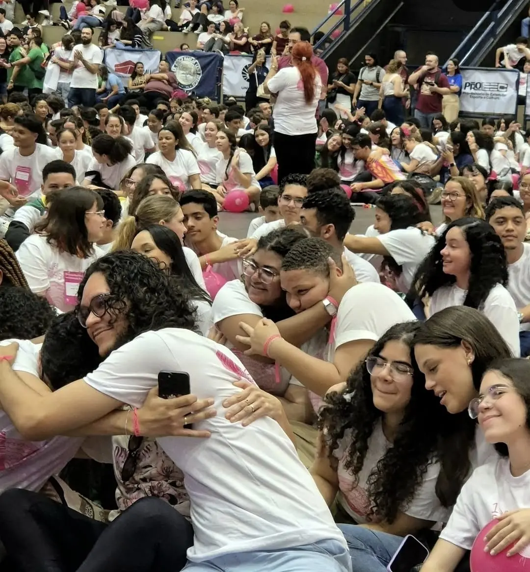 Alunos se abraçam em quadra lotada