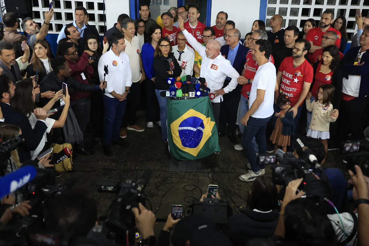 Presidente Lula (de braço levantado) falou à imprensa na companhia da esposa Janja e diversos apoiadores.