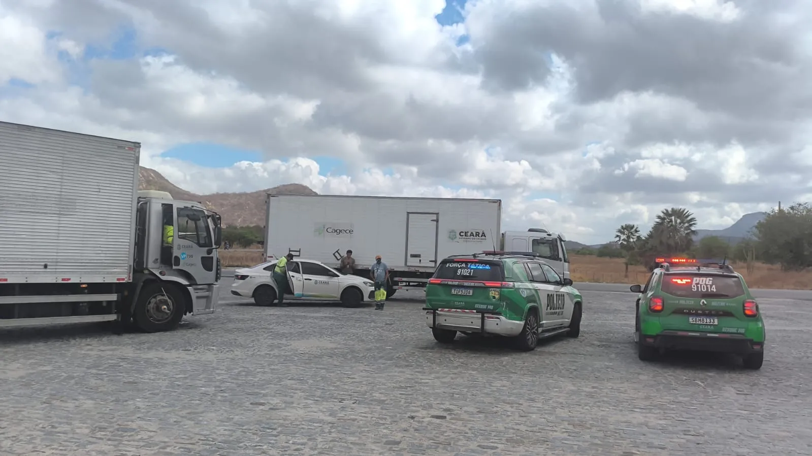 Viaturas da PMCE acompanham os caminhões que carregam os garrafões de água.